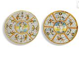 two plates with designs on them on a white surface