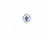 un gros plan d'une bague ornée d'une pierre bleue entourée de diamants bleus et blancs