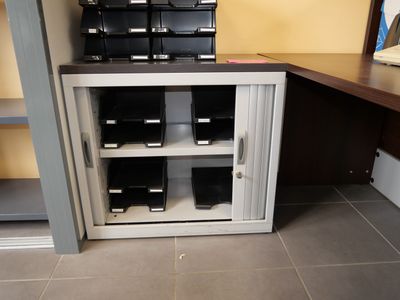 a small cabinet with a bunch of files on top of it