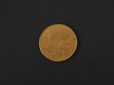 a gold coin on a black surface