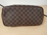 a brown and black checkered toilet bag sitting on top of a wooden table