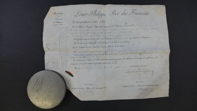un vieux document posé sur une table, avec une pierre à côté