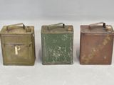 three old tin cans are lined up on a white surface