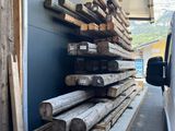 un camion garé à côté d'un tas de bois