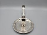 a silver plate with a small cup and saucer on it