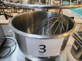 a large metal bowl with a whisk inside of it