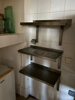 a small kitchen with a sink and shelves in it