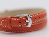 an orange leather watch strap with a silver buckle on a white surface