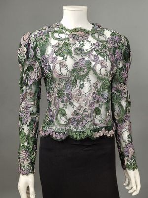 a green and purple blouse with a floral pattern on the shoulders