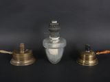 three antique brass and glass oil lamps on a black background