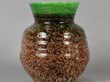 un vase vert et marron posé sur une table