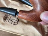 a person holding a pipe in their hand near a bag
