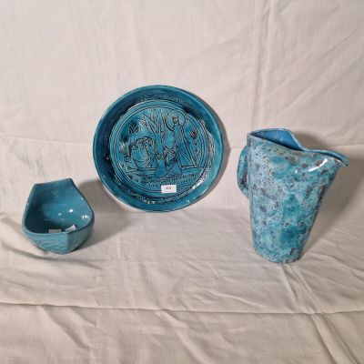 three pieces of pottery sitting on a white surface