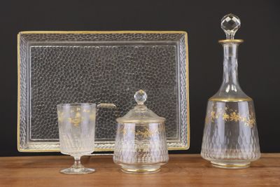 trois objets en verre posés sur une table à côté d'un cadre photo