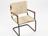 the chair is made of metal and has a beige upholstered upholstered seat