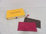 Deux portefeuilles Louis Vuitton sont posés l'un à côté de l'autre sur une table