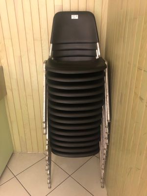 une pile de chaises noires dans un coin de la salle de bains