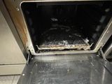 a dirty oven with a metal pan inside of it