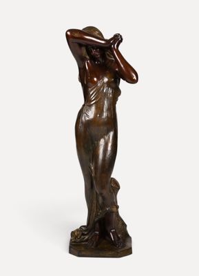 une statue en bronze représentant une femme, les mains posées sur la tête