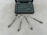 cinq cuillères en argent et deux cuillères en argent dans un coffret