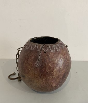 a brown vase with a chain around it on a table