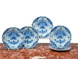 cinq assiettes bleues et blanches et une paire de ciseaux posés sur une table