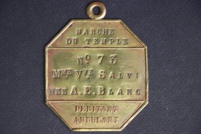 a gold medal on a black surface with a name on it