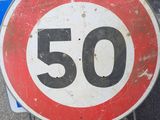 a red and white sign with the number 50 on it
