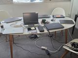 une table sur laquelle sont posés plusieurs ordinateurs portables, dans une pièce