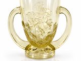 a yellow glass cup with a handle on a white surface