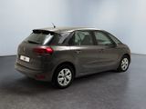 the back of a grey car in a room with a black floor