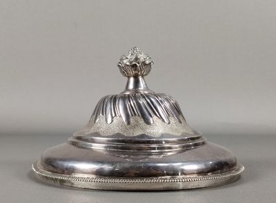an antique silver plate with a flower on top of it