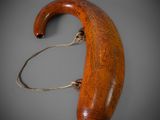 an old wooden walking stick with a handle on a gray surface