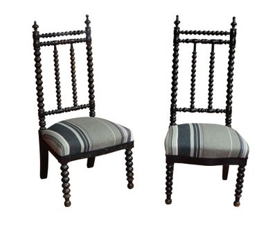 une paire de chaises rayées noir et blanc avec des pieds en bois