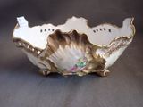 a white and gold bowl with a flower design on it