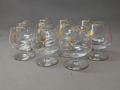 six verres à vin à bord doré sont alignés sur une table