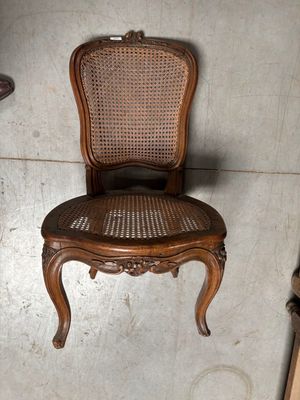 une chaise en bois avec un dossier et une assise en osier