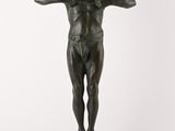 statue d'un homme debout sur un socle, les mains sur les hanches
