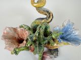 a figurine of a snake and flowers on a white surface