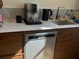 une cuisine équipée d'un évier, d'un lave-vaisselle et d'une cafetière