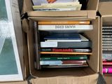 many books in a cardboard box on the ground