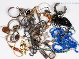 une pile de bijoux assortis sur une surface blanche