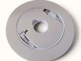 a picture of a white circular device with a cable connected to it