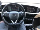 a picture of a man sitting in a car with his feet on the steering wheel
