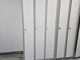 several white lockers in a room with tile flooring