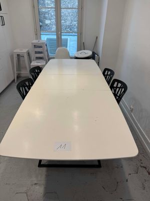 une longue table blanche au milieu d'une pièce