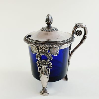 a blue glass cup with a silver lid on a white background