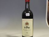 une bouteille de vin posée sur un comptoir à côté d'un verre de vin
