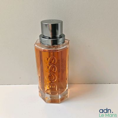 une photo d'un flacon de parfum posé sur une table
