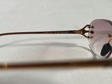 glasses with gold rims on a white surface with a pair of glasses in the foreground